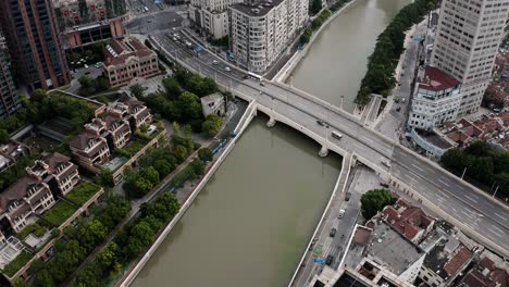 Shanghai-Innenstadt-Wohnviertel,-Flussufer-Mit-Stark-Befahrener-Straßenbrücke,-Antenne