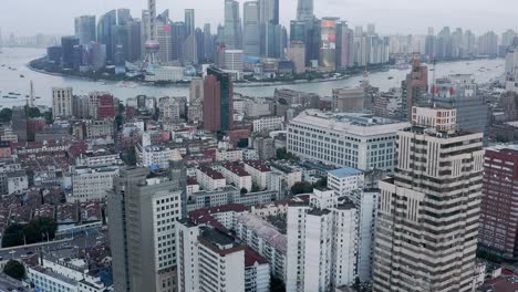 Shanghai-business-district-reveal-from-downtown-city-suburb,-aerial-view