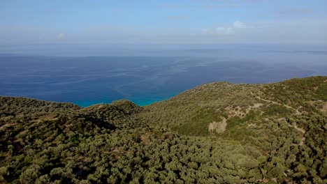 Green-hills-with-olive-trees-bordered-by-blue-azure-sea-in-Mediterranean-riviera-seascape