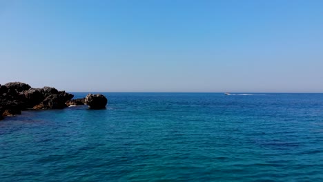Blue-azure-sea-water-washing-cliffs-of-Mediterranean-coastline-on-a-summer-vacation-day