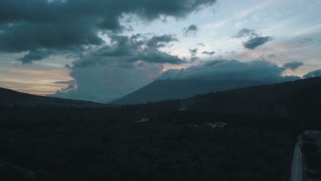 Drone-aerial-of-a-forest-and-a-volcano-in-the-back-during-sunset-in-Guatemala