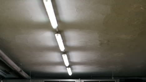 Leuchtstofflampen-Flackern-In-Einem-Pechschwarzen-Raum-Und-Offenbaren-Einen-Kalten,-Dunklen,-Unheimlichen-Betonkeller-Mit-Klimaanlage