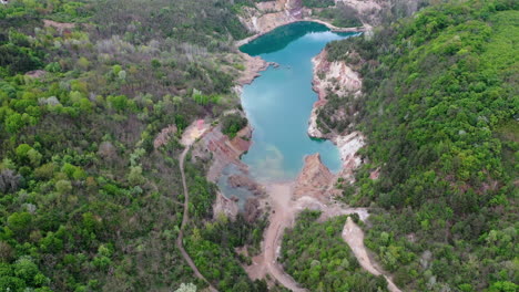 Down-fly-over-view-of-a-old-mine-construction-site-with-blue-lake-in-hungary