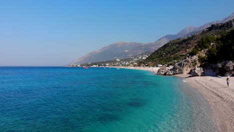 Paradiesstrand-Mit-Kieselsteinen,-Die-Von-Kristallklarem-Azurblauem-Meerwasser-An-Der-Wunderschönen-Küste-Albaniens-Gewaschen-Werden