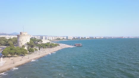 Der-Wunderschöne-Weiße-Turm-In-Thessaloniki,-Griechenland,-Vor-Einem-Tiefblauen-Ozean-Tagsüber---Luftaufnahme