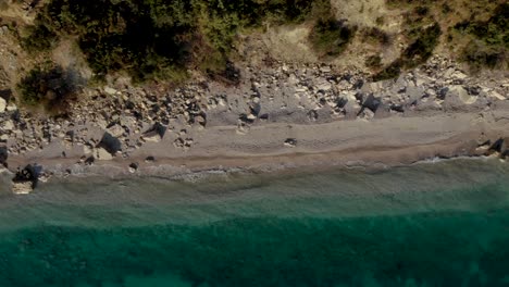 Smaragdgrünes-Meerwasser-Wäscht-Felsigen-Strand-An-Wunderschöner-Küste,-Kopierraum-Mit-Türkisfarbener-Textur