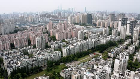 Shanghai-cityscape,-rising-aerial-view-over-China-urban-city-tower-blocks