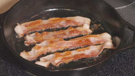 Cast-Iron-pan-on-stove-turning-browning-bacon