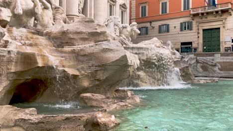 Beautiful-Fountain-With-Clear-Waters-Flowing-From-Ornate-Stoneworks-Situated-In-Palazzo-Poli-Monumental-Facade-In-Trevi,-Rome,-Italy---Slow-Motion
