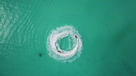 Aufsteigende-Drohnenaufnahme-Von-Paaren,-Die-Im-Türkisfarbenen-Wasser-In-Der-Nähe-Der-Malediven-Jetski-Fahren