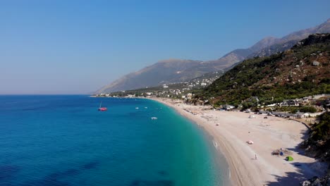 Unberührter-Strand-Von-Dhermi-In-Albanien-Mit-Sand-Und-Felsen,-Umspült-Von-Ruhigem,-Kristallklarem,-Azurblauem-Meerwasser