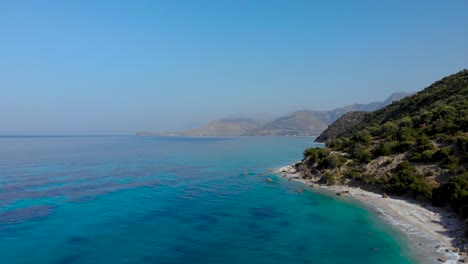 Hidden-beaches-on-beautiful-coastline-of-Mediterranean-with-azure-sea-water-and-mountains-background