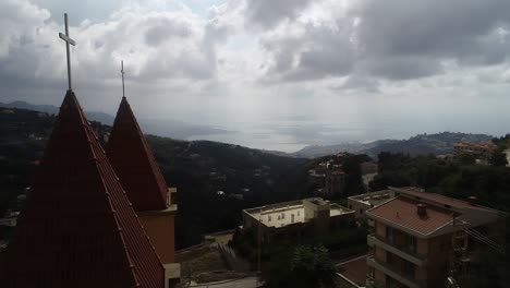 Majestic-scenery-of-Lebanese-religious-architecture,-Church-towers,-aerial-drone-view-on-cloudy-day,-circle-shot