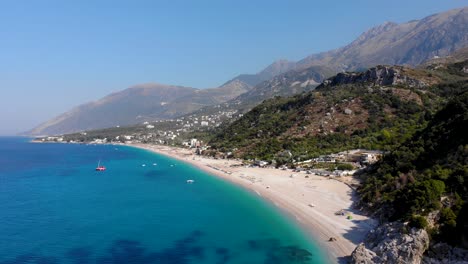 Beautiful-seaside-with-resorts-and-tourist-villas-on-hills-above-beach-and-blue-azure-water-in-Albania