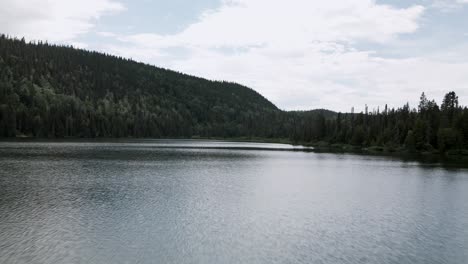 Überfliegen-Des-Ruhigen-Wassers-Des-Verlorenen-Sees-Mit-üppigem-Grünem-Wald-Auf-Den-Bergen-Auf-Der-Gaspesie-Halbinsel,-Quebec,-Kanada