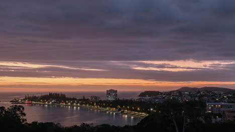 Sunset-timelapse-of-Anse-Vata-beach-on-New-Caledonia-and-night-traffic-driving-on-famous-Promenade-Pierre-Vernier