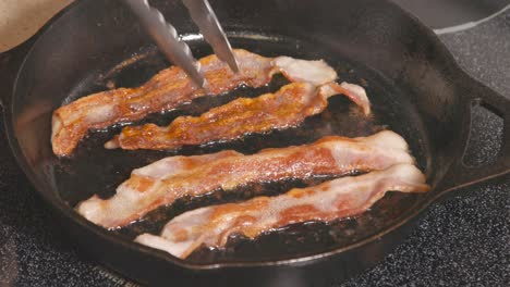 Cast-Iron-skillet-on-stove-frying-bacon