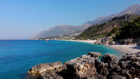 Paradise-beach-surrounded-by-cliffs-washed-by-calm-clear-water-of-azure-Mediterranean-sea-in-Albania