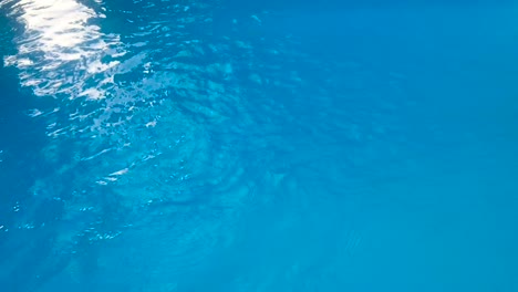 Schnelles-Azurblaues-Schwimmbadwasser,-Das-In-4K-Mit-Sonnenlichtreflexion-Plätschert