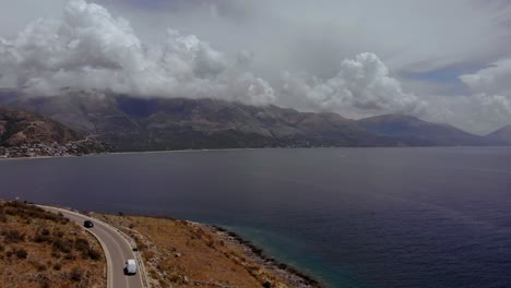 Seaside-of-Mediterranean-with-road-alongside-sea-lagoon-and-mountains-background-on-a-cloudy-day