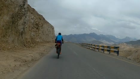 Motociclista-Acelerando-En-La-Carretera-De-Montaña-A-Leh-En-Ladakh,-India---Tiro-Rodante