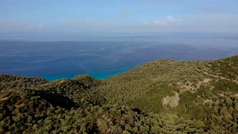 Seascape-panoramic-view-of-green-hills-with-olive-trees-and-blue-azure-sea-background-in-Albania