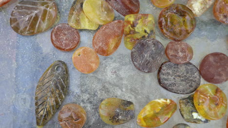 Top-View-Shot-of-Scatterd-Pieces-of-Amber-in-Variuos-Colours-and-Shapes