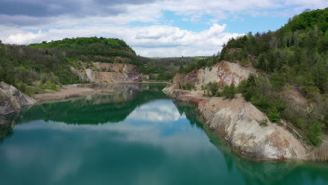 Down-fly-over-view-of-a-old-mine-construction-site-with-blue-lake