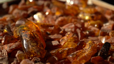 Handhel-Shot-of-Unpolished-Scattered-Pieces-of-Amber-with-Rich-Orange-Colour