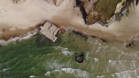 Aerial-top-down-with-no-movement-of-old-German-bunkers-in-the-water-slowly-eroding-by-the-ocean-while-seagulls-fly-around-at-the-Danish-west-coast