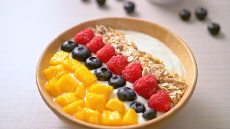 homemade-yoghurt-bowl-with-raspberry,-blueberry,-mango-and-granola---healthy-food-style