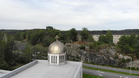 Drone-flying-towards-bronze-dome-of-Orthodox-Church,-Gothenburg