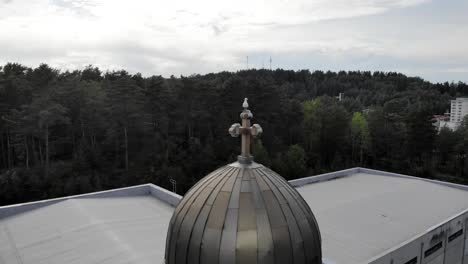 Drohne-Schoss-Um-Einen-Vogel-Auf-Einem-Kirchenkuppelkreuz-Herum,-Dunkler,-Bewölkter-Tag,-In-Gotland,-Schweden---Kreisend,-Luftbild