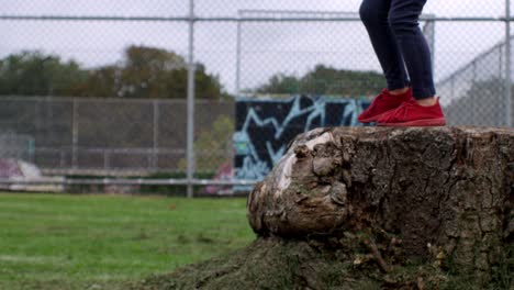 Girl-Jumping-From-Logs-red-shoes