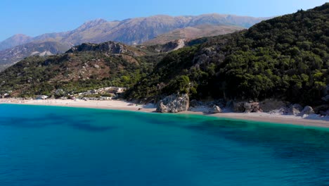 Tranquil-beach-with-no-people-on-a-remote-shoreline-with-sand-washed-by-blue-azure-sea-water-in-Albania