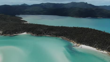 Flying-over-Amazing-Clear-Green-Water-and-White-Sandy-Beaches-in-the-Whitsundays,-near-the-Great-Barrier-Reef,-Drone