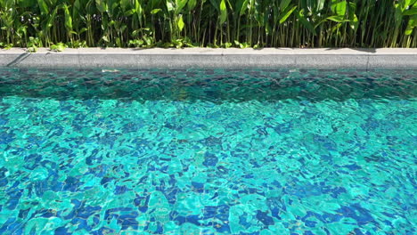 Crystal-clear-swimming-exotic-pool-water,-with-the-light-reflecting-off-the-surface