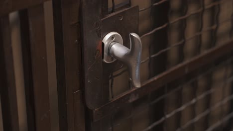 Close-shot-of-steel-door-handle-on-an-old-fashioned-descending-elevator