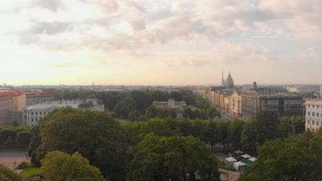 Scenic-aerial-view-revealing-breathtaking-panorama-of-Riga-skyline-sunset-on-sunny-summer-day,-rising