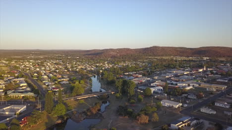Aerial:-Drone-ascending-over-the-town-during-golden-hour,-near-Stanthorpe,-Queensland