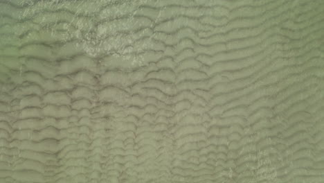 AERIAL:-Medium-Shot-of-Top-View-Shot-of-Waves-on-the-Shallow-Shore-and-Spilling-on-Sand