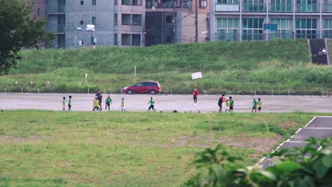 Japanese-Children-Playing-Soccer-On-The-Field-At-Daytime-In-Tokyo,-Japan