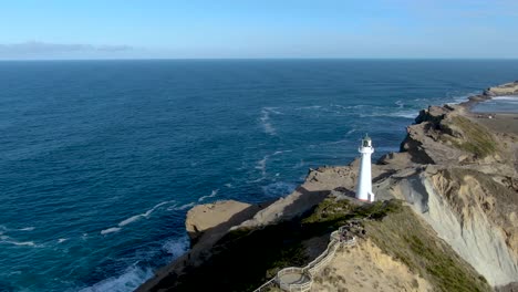 Lighthouse-Tower---Navigational-Beacon-on-Ocean-Coast-of-New-Zealand---Aerial-Drone-Flyover