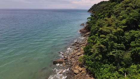 Drone-dolly-shot-of-jungle-and-rocky-coastline-with-ocean