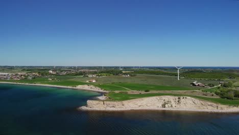 Aerial-of-Danish-coast-on-a-hot-summer-day-with-green-fields-and-calm-ocean