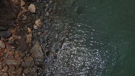 Drone-vertical-tracking-shot-of-Ocean-meets-rocks-on-a-tropical-Island