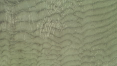 AERIAL:-Close-Up-of-Sea-Bottom-with-Waves-on-the-Surface-of-the-Sea