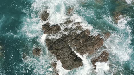 Drone-aerial-top-view-of-waves-crashing-on-the-rocks-in-the-ocean