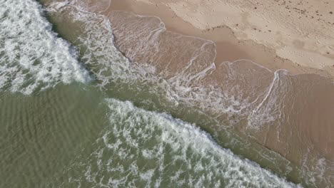 Luftaufnahme-Von-Klaren-Meereswellen,-Die-Sich-Langsam-Am-Weißen-Sandstrand-Brechen