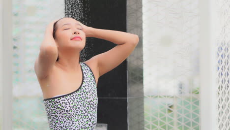 Attractive-long-hair-asian-girl-in-swimsuits-stand-ender-the-shower-slow-motion